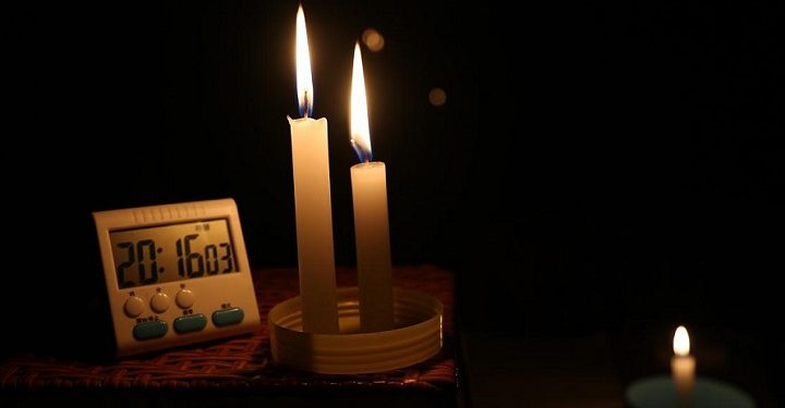 A clock seen next to candles during a power outage