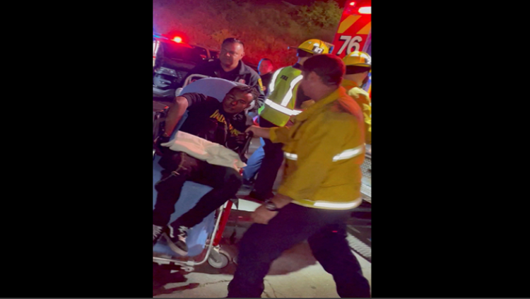 A man is transported into an ambulance after comedian Dave Chappelle was attacked on stage during stand-up Netflix show at the Hollywood Bowl, in Los Angeles, U.S., May 3, 2022, in this still image obtained from a social media video. Theodore Nwajei/via REUTERS