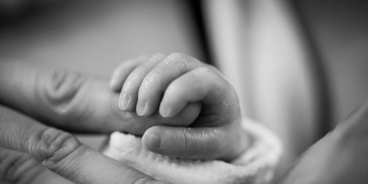 File Image: A mother holds the hand of her  child.