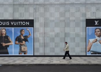 A man wearing a face mask walks past a store of French luxury brand Louis Vuitton at a shopping mall in Wuhan, the epicentre of the novel coronavirus outbreak, Hubei province, China February 25, 2020. REUTERS/Stringer/Files