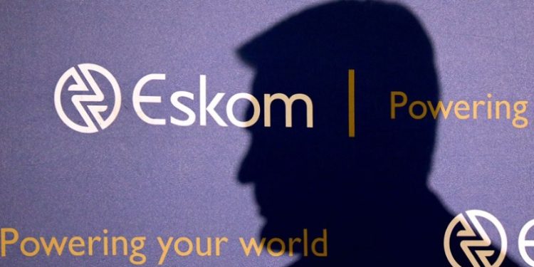 File image: The shadow of Eskom Chief Executive Officer, Andre de Ruyter, is seen behind the power utility's logo.