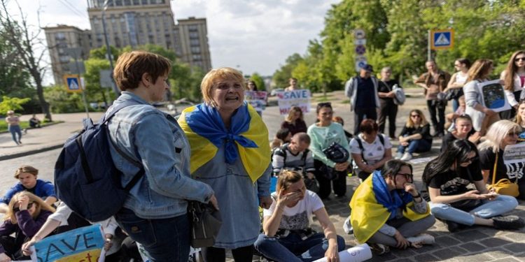 A woman reacts as relatives of Ukrainian service members who are besieged inside of the Azovstal Iron and Steel Works in Mariupol attend a protest to demand a rescue operation, near the presidential palace in downtown Kyiv, Ukraine May 12, 2022.