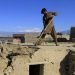 File Photo: A man clears rubble from the roof of his house after an earthquake, in Behsud district of Jalalabad province, Afghanistan October 27, 2015.