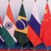 A staff worker stands behind the national flags of Brazil, Russia, China, South Africa and India to tidy the flags before a group photo during the BRICS Summit at the Xiamen International Conference and Exhibition Center in Xiamen, southeastern China's Fujian Province, China September 4, 2017.
