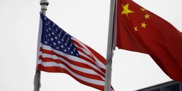 Chinese and US flags flutter outside the building of an American company in Beijing, China January 21, 2021.