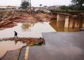 A person walks around a damaged bridge caused by flooding in Umlazi near Durban, South Africa, April 16, 2022.