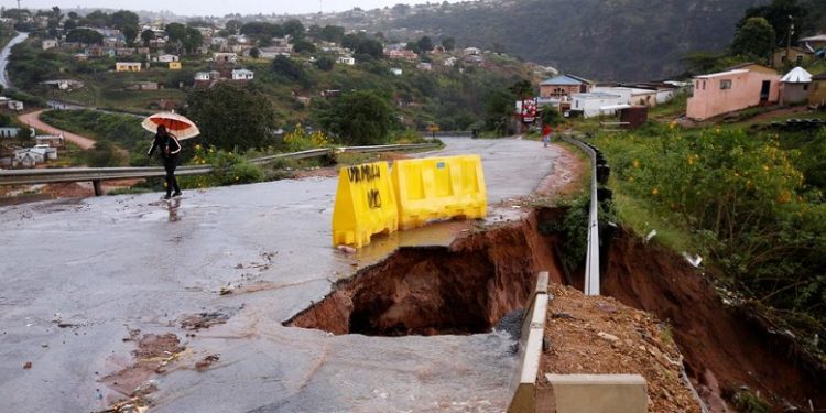 Water from heavy rains runs along a road, which was damaged during previous flooding, in kwaNdengezi near Durban, South Africa, May 22, 2022.