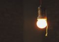 A light bulb shines in a dark room.