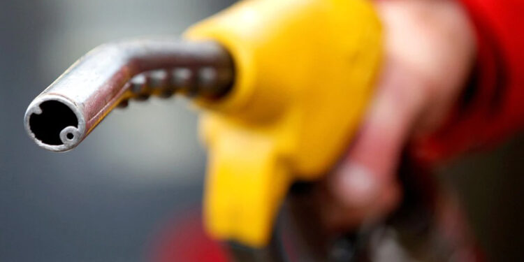 A petrol station attendant prepares to refuel a car.