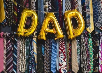 Ties and a DAD foil balloon banner seen hung during a Father's Day celebration.