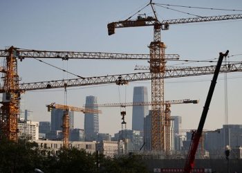 A view shows cranes in front of the skyline of the Central Business District (CBD) in Beijing, China, October 18, 2021.