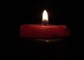 A candle lit in a dark room.