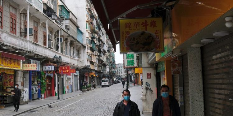 People wear masks as they walk near Ruins of St. Paul’s, following the coronavirus outbreak in Macau in 2020.