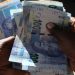 A street money changer counts South African Rands.