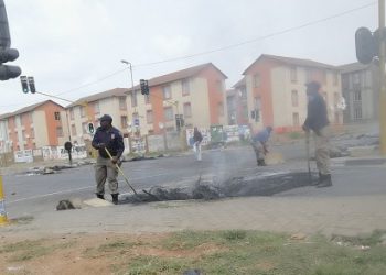 File: JMPD officers cleaning up Main Reef Road after a protest in Pennyville  in 2019.