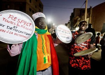 Ibrahima Soumare, 47, a supporter of Senegal's main opposition coalition Yewwi Askan Wi holds signs glued on pot lids during a protest over the disqualification of their national list for the July 31 legislative election in Dakar, Senegal, June 22.