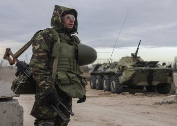 A Ukrainian serviceman guards a checkpoint near the village of Strelkovo in Kherson region adjacent to Crimea.