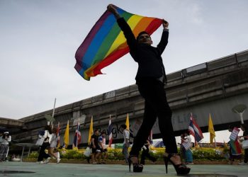 An LGBT activist holding a rainbow flag poses for pictures as he attends an International Day Against Homophobia, Transphobia and Biphobia at Bangkok's Art Center, Thailand, May 17, 2019. REUTERS/Athit Perawongmetha