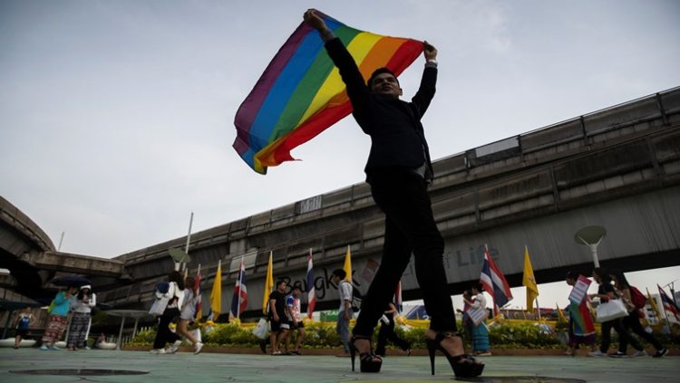 An LGBT activist holding a rainbow flag poses for pictures as he attends an International Day Against Homophobia, Transphobia and Biphobia at Bangkok's Art Center, Thailand, May 17, 2019. REUTERS/Athit Perawongmetha