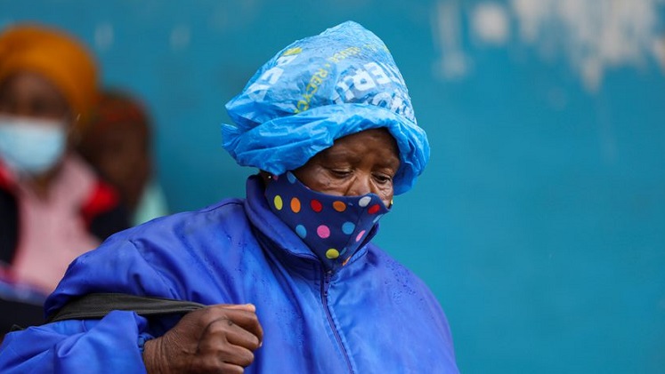 A woman wearing a protective face mask against COVID-19 looks on at Tsomo, a town in the Eastern Cape