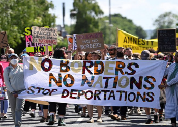 Demonstrators protest outside of an airport perimeter fence against a planned deportation of asylum seekers from Britain to Rwanda, at Gatwick Airport near Crawley, Britain, June 12, 2022.