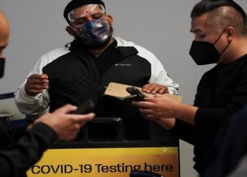 Travellers wait in line to get tests for the coronavirus disease (COVID-19) at a pop-up clinic at Tom Bradley International Terminal at Los Angeles International Airport, California, US, December 22, 2021.
