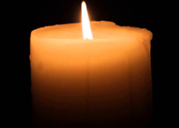 A candle burns at a funeral.