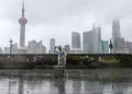 A man with luggage walks in the rain on The Bund as Typhoon In-fa approaches Shanghai, China July 25, 2021.