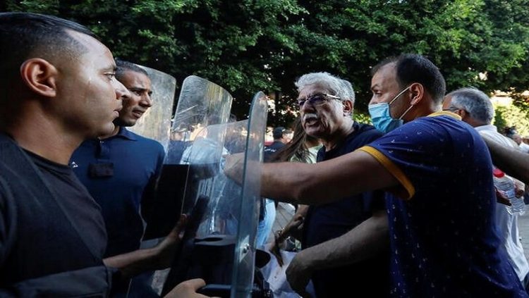 Hamma al-Hammami, a leftist activist and former political prisoner, confronts with police during a protest organized by Tunisian civil society groups against the President Kais Saied's upcoming referendum on a new constitution in Tunis, Tunisia July 22, 2022.
