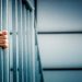 A prisoner seen behind bars