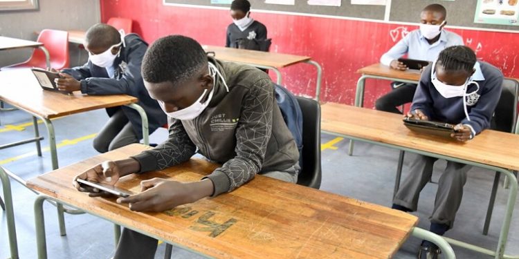 Learners seen working on their tablets in a classroom