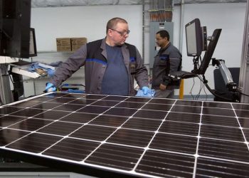 Production operator John White checks a panel at the SolarWorld solar panel.