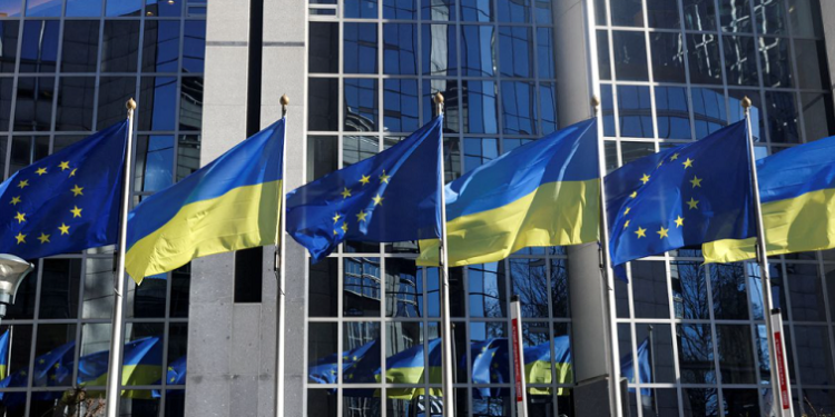 The flags of the European Union and Ukraine flutter outside the European Parliament building.