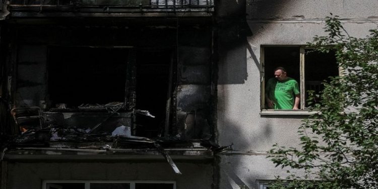 A local resident looks out through a broken window in his flat in a residential building damaged by a Russian military strike, amid Russia's invasion on Ukraine, in Kramatorsk, in Donetsk region, Ukraine July 19, 2022.