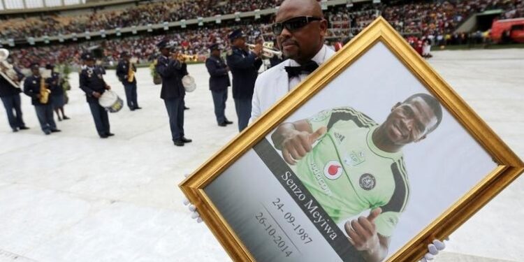 A man holds a framed picture of South African national soccer team goalkeeper and captain, Senzo Meyiwa during his funeral service in Durban November 1, 2014.
