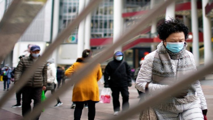 People wearing face masks following the coronavirus disease (COVID-19) outbreak walk on a shopping street in Shanghai, China, December 14, 2021.