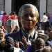 A crowd outside Parliament takes photos of the recently unveiled bust statue of former President of South Africa Nelson Mandela in Parliament.