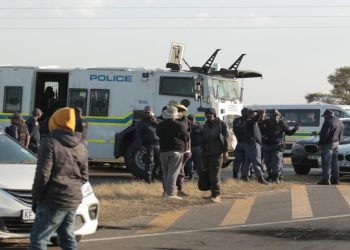 Police officers intervene during protests against illegal mining in Krugersdorp, August 4, 2022.