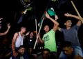 Palestinians celebrate on a street after a ceasefire was announced, in Gaza City August 8, 2022.