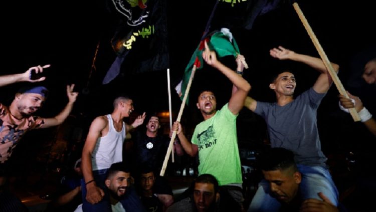 Palestinians celebrate on a street after a ceasefire was announced, in Gaza City August 8, 2022.