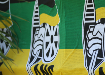 The ANC logo and colours are displayed on a press conference table.