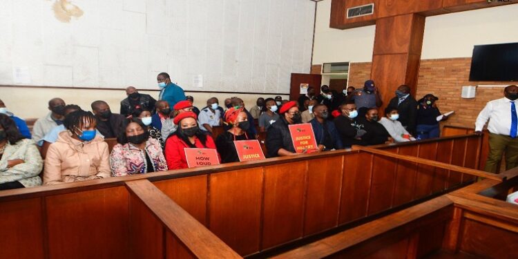 Members of the EFF with posters and Hillary Gardee’s family (front row) are seen inside the Nelspruit Magistrates’ Court in Mbombela on 09 May 2022.