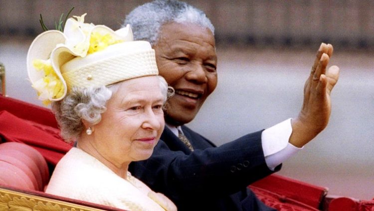 Nelson Mandela and Queen Elizabeth II ride in a carriage outside Buckingham Palace, June 12, 2013.