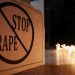 A poster is seen at a candle-lit march against rape.