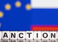 Plastic letters arranged to read "Sanctions" are placed in front the flag colors of EU and Russia in this illustration taken February 28, 2022. REUTERS/Dado Ruvic/Illustration