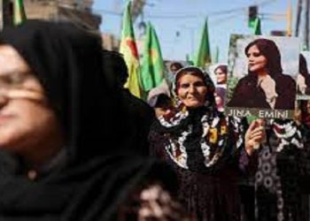 Women carry flags and pictures during a protest over the death of 22-year-old Kurdish woman Mahsa Amini in Iran
