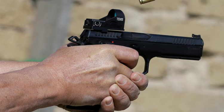 A man fires a shot from a handgun