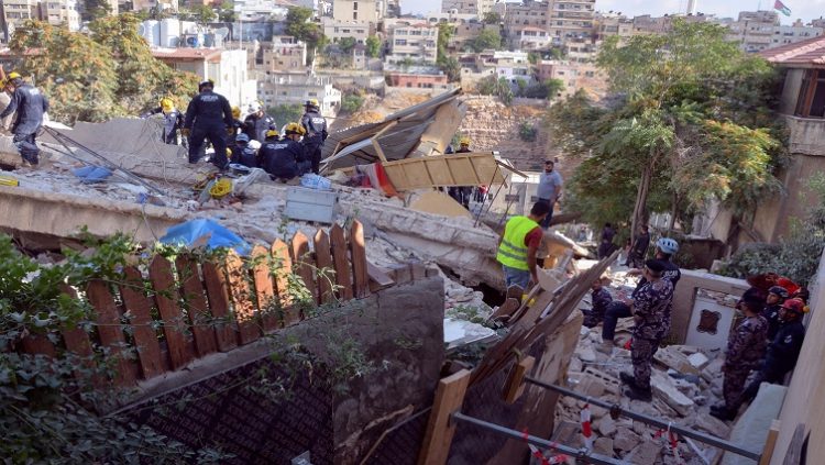 Civil defence members search for survivors at the site of a four-storey residential building collapse in Amman, Jordan.