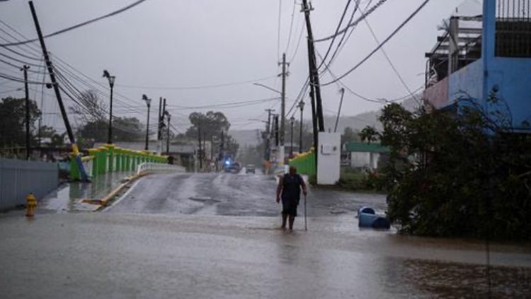 A man wades through a flooded street after Hurricane Fiona affected the area in Yauco, Puerto Rico September 18, 2022.