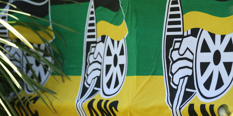 The ANC logo and colours are displayed on a press conference table
